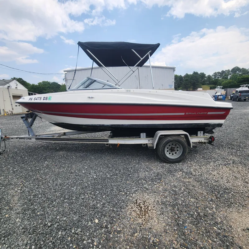 Slide: The Image of 2018 Bayliner 185 Bowrider on trailer, red and white, with black canopy. - 4