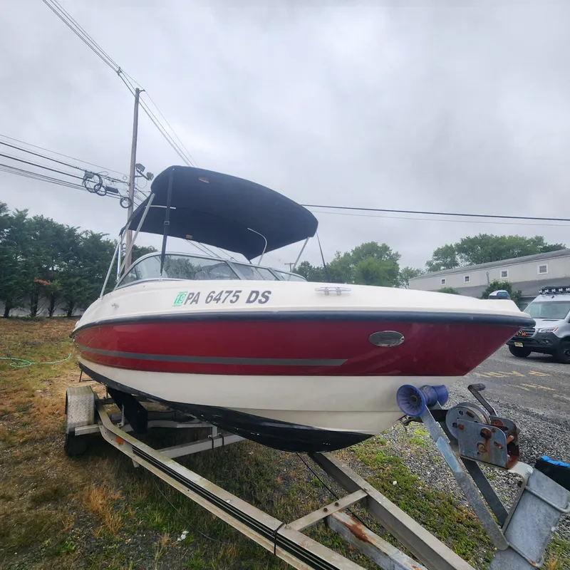 Slide: The Image of 2018 Bayliner 185 Bowrider boat on a trailer, red and white, with a black canopy. - 6