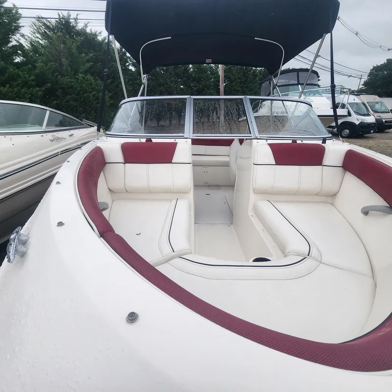 Slide: The Image of 2018 Bayliner 185 Bowrider with red and white interior, black bimini top. - 7