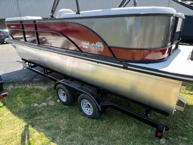 Slide: The Image of 2023 SunCatcher SELECT pontoon boat on a trailer, side view. - 2
