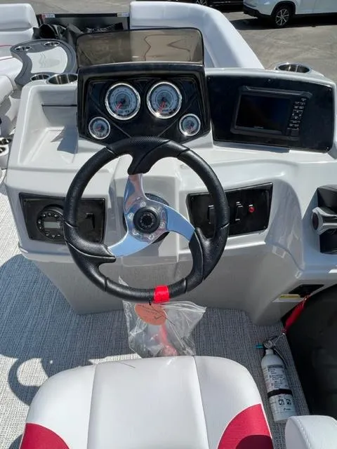 Slide: The Image of 2023 SunCatcher SELECT boat dashboard with steering wheel, gauges, and navigation system. - 6