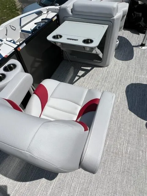 Slide: The Image of 2023 SunCatcher SELECT boat interior with white and red seating and a foldable table. - 8