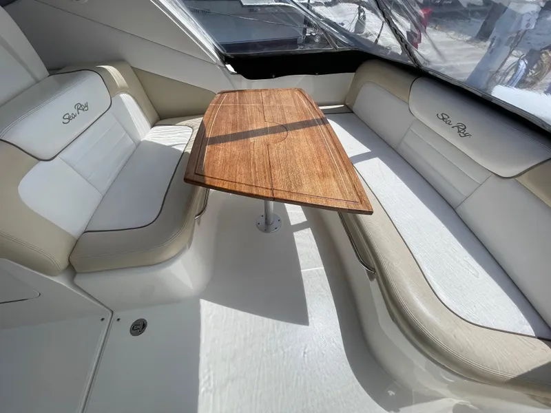 Slide: The Image of 2012 Sea Ray 350 Sundancer interior seating area with wooden table. - 10