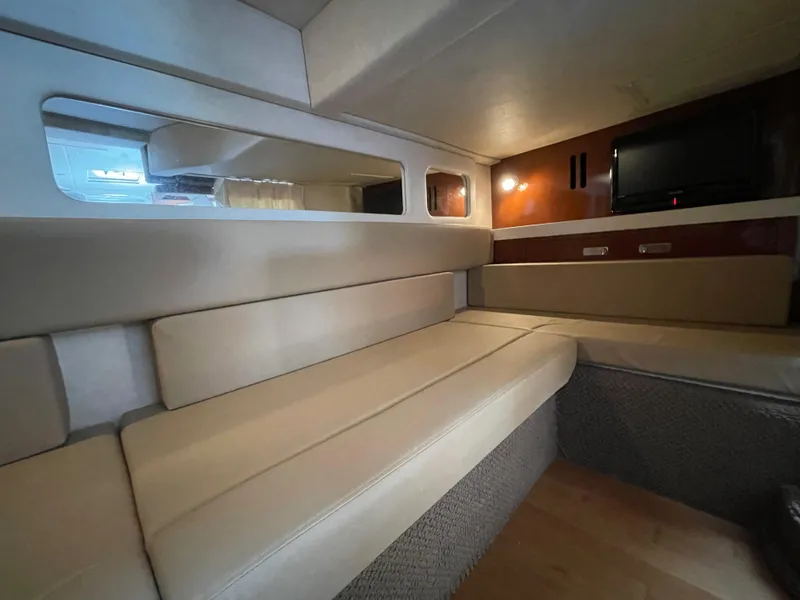 Slide: The Image of Interior cabin of 2012 Sea Ray 350 Sundancer with beige seating and wall-mounted TV. - 21