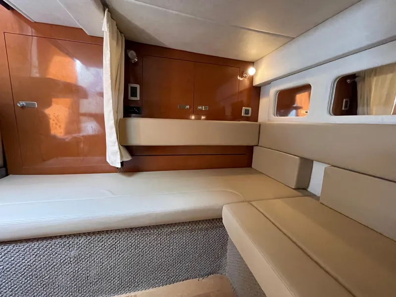 Slide: The Image of Interior cabin of 2012 Sea Ray 350 Sundancer with beige seating and wooden cabinetry. - 22