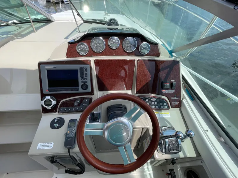 Slide: The Image of 2012 Sea Ray 350 Sundancer helm with wood accents and modern navigation controls. - 4