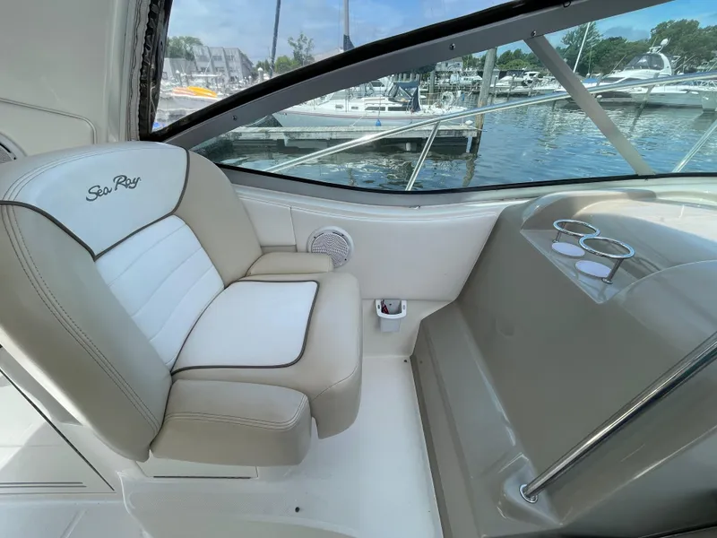 Slide: The Image of 2012 Sea Ray 350 Sundancer cockpit seating with marina view. - 7