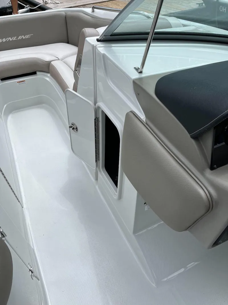 Slide: The Image of 2023 Crownline E 235 XS boat interior with open storage compartment. - 11