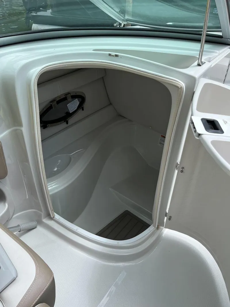 Slide: The Image of 2023 Crownline E 235 XS boat interior cabin with white and beige finish. - 12