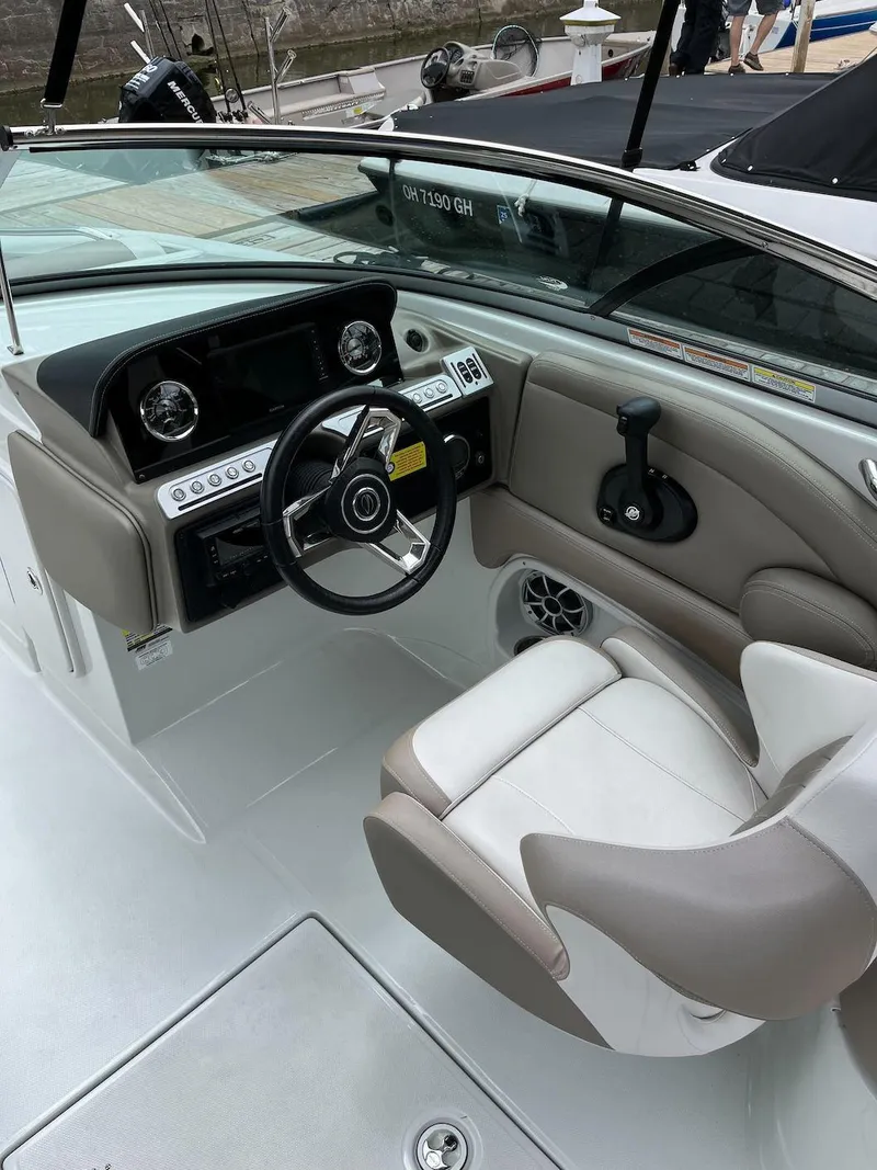 Slide: The Image of 2023 Crownline E 235 XS boat cockpit with steering wheel and captain's chair. - 6
