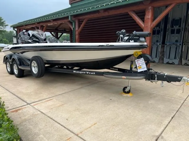 Slide: The Image of 2023 Ranger Z521R fishing boat on a Ranger Trail trailer, parked outside a log cabin. - 0