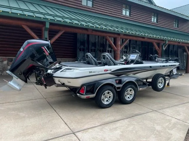 Slide: The Image of 2023 Ranger Z521R fishing boat on trailer outside log cabin. - 1