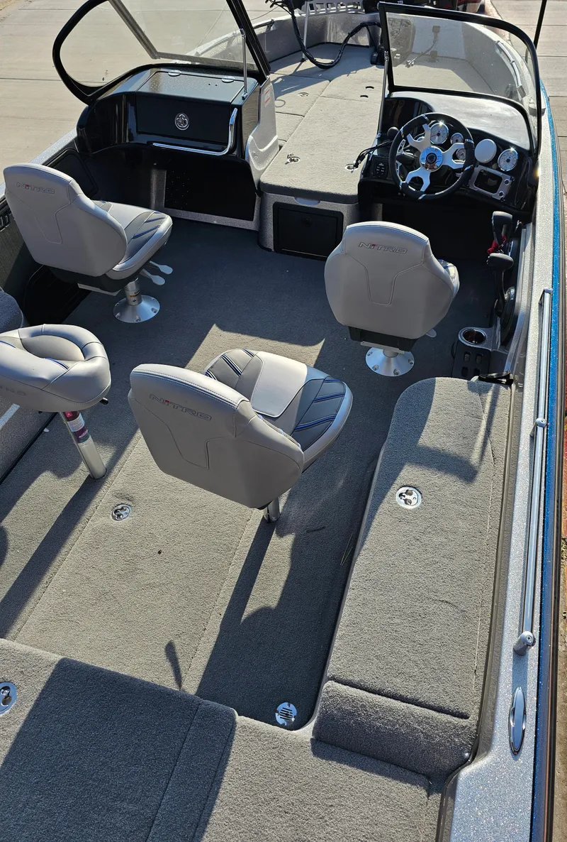 Slide: The Image of 2023 Nitro ZV21 boat interior with gray seating and carpeted flooring. - 2