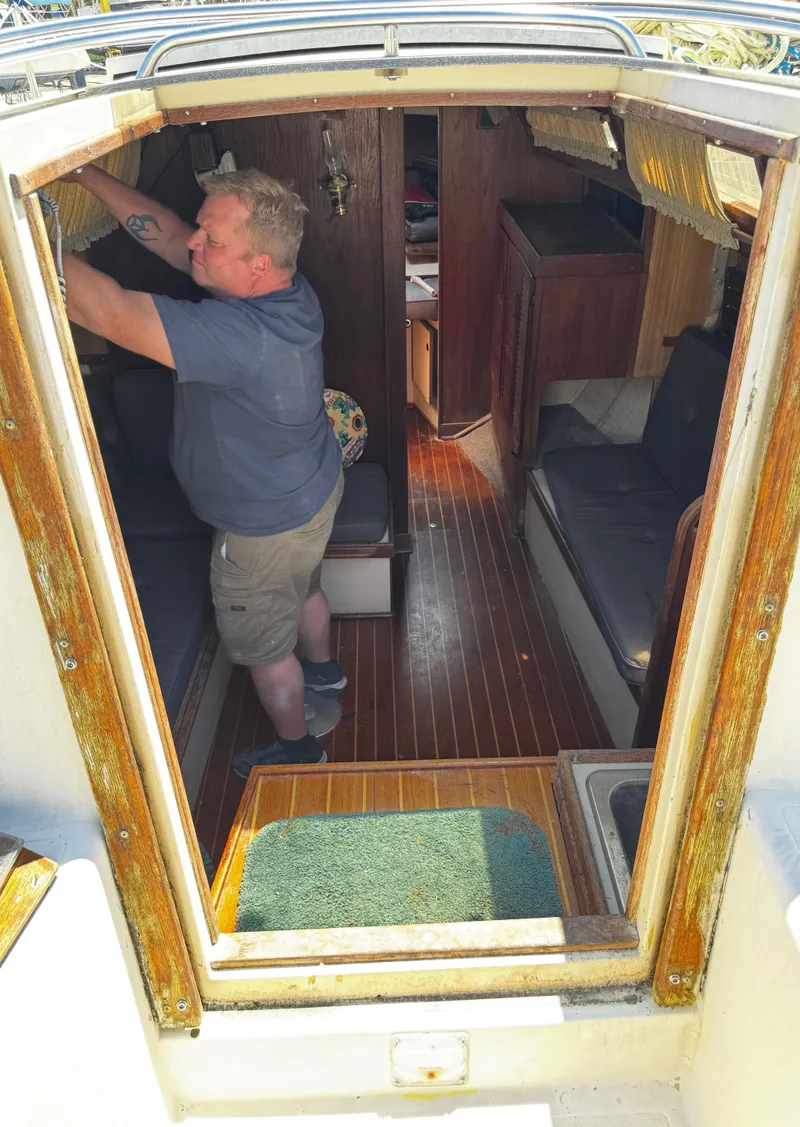 Slide: The Image of Man inside 1984 S2 9.2 sailboat cabin with wooden interior. - 21