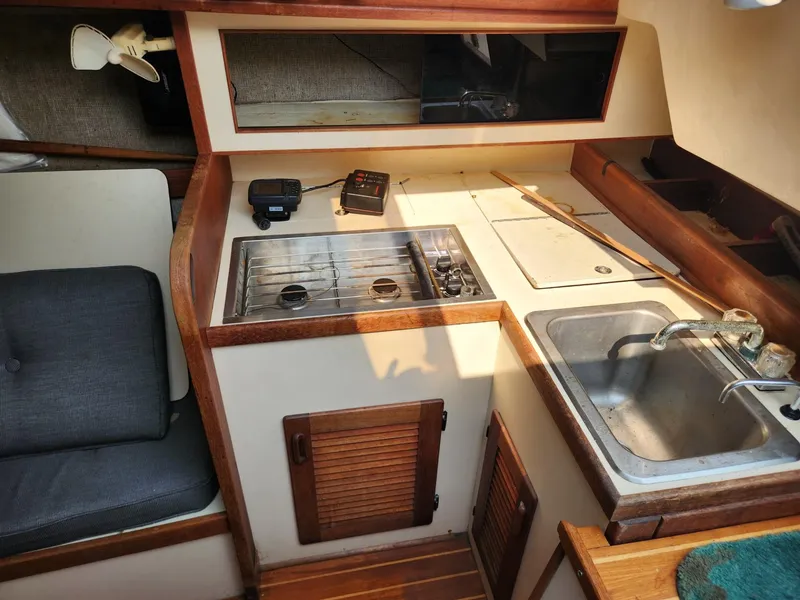 Slide: The Image of 1984 S2 9.2 sailboat galley with stove, sink, and seating area. - 30