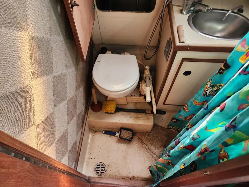 Slide: The Image of 1984 S2 9.2 boat bathroom with toilet, sink, and cleaning supplies. - 40