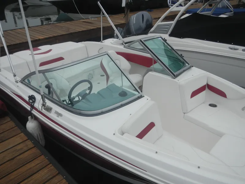 The Image of 2012 Chaparral 19 H2O Sport boat docked, featuring white and red interior. - 0