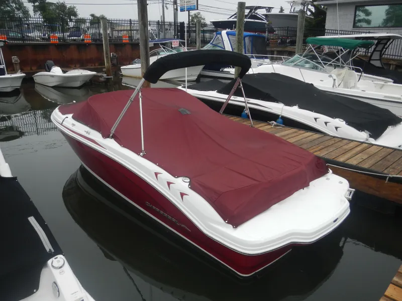 Slide: The Image of 2012 Chaparral 19 H2O Sport boat with red cover docked in marina. - 2