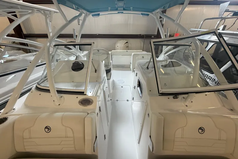 Slide: The Image of 2024 Edgewater 248CX Crossover boat interior with seating and windshield in showroom. - 10