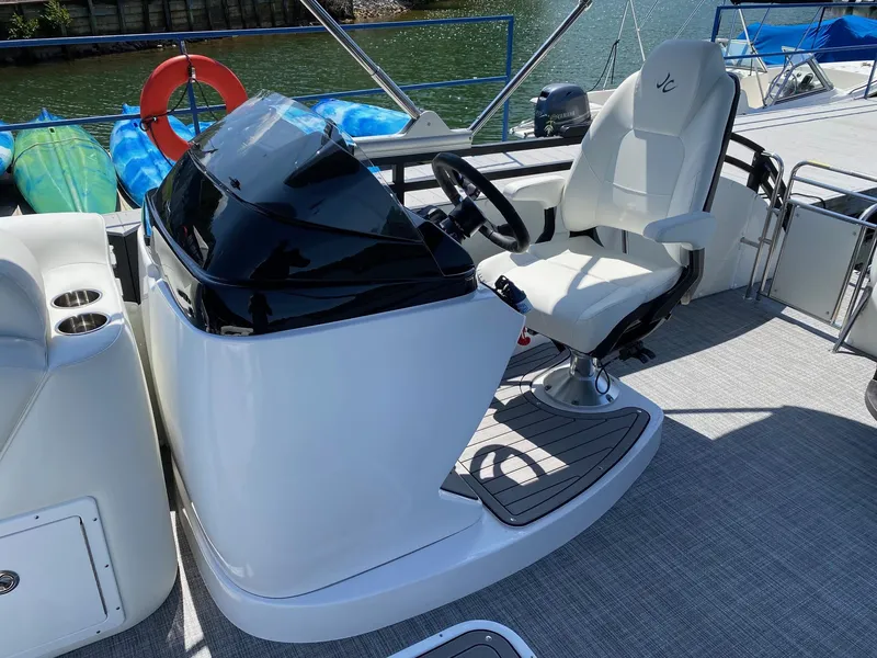 Slide: The Image of 2024 JC NEPTOON SPORT 21TT boat helm with white captain's chair and steering console. - 12