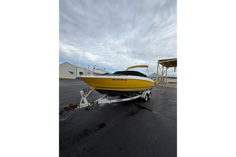 Slide: The Image of Yellow 2007 Monterey 214FS boat on trailer, parked outdoors under cloudy sky. - 15