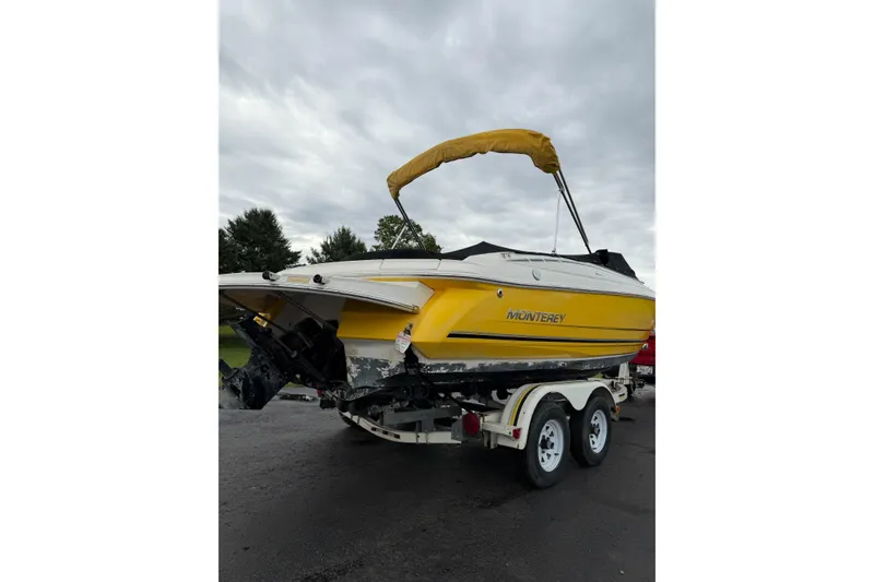 Slide: The Image of 2007 Monterey 214FS boat with yellow hull on a trailer, overcast sky. - 17