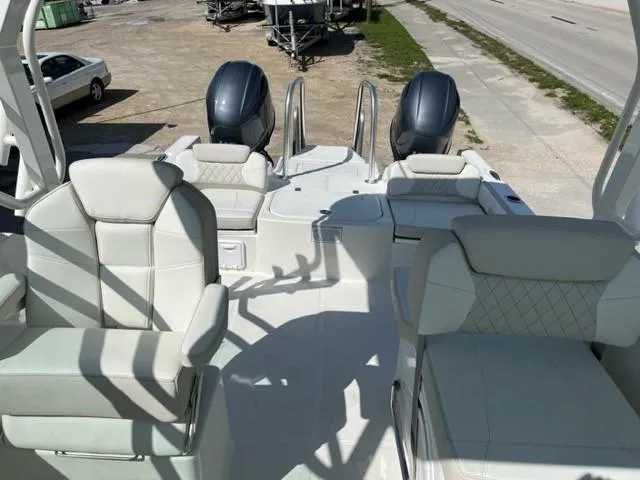 Slide: The Image of 2023 World Cat 230 DC boat interior with dual engines and white seating. - 2