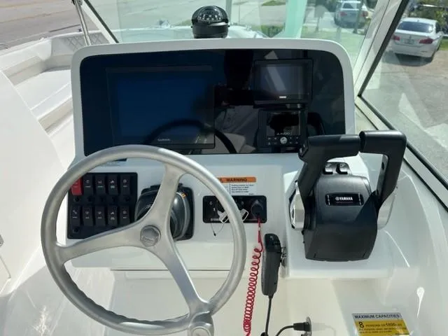 Slide: The Image of 2023 World Cat 230 DC boat dashboard with steering wheel and Yamaha controls. - 4