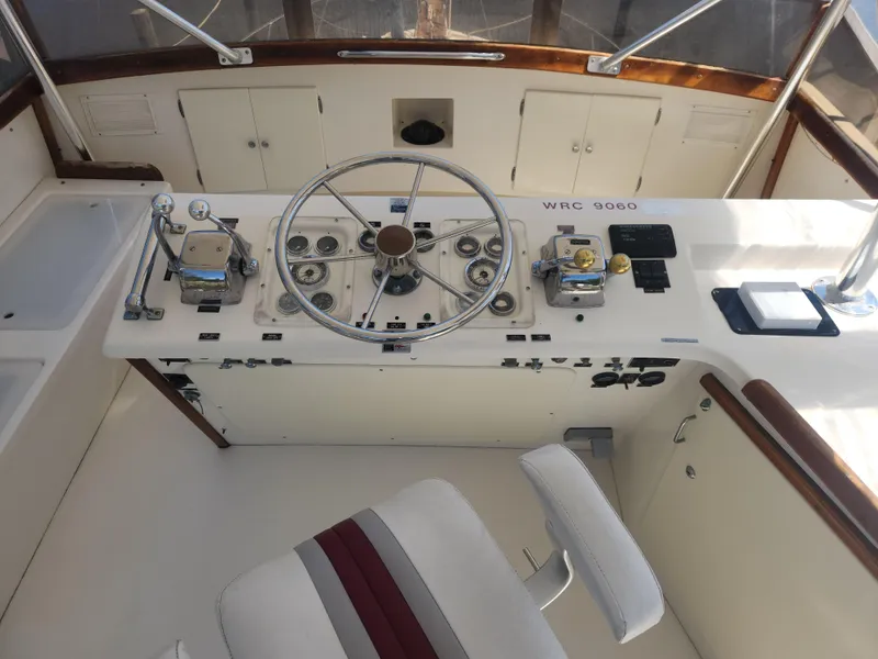 Slide: The Image of 1984 Post Sportfish boat helm with steering wheel, controls, and gauges. - 1