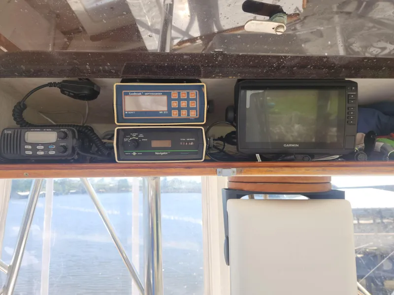 Slide: The Image of 1984 Post Sportfish boat dashboard with depth sounder, radio, and Garmin navigation equipment. - 2