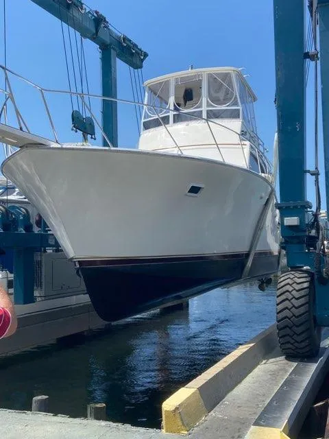 Slide: The Image of 1984 Post Sportfish boat being lifted at a marina. - 3