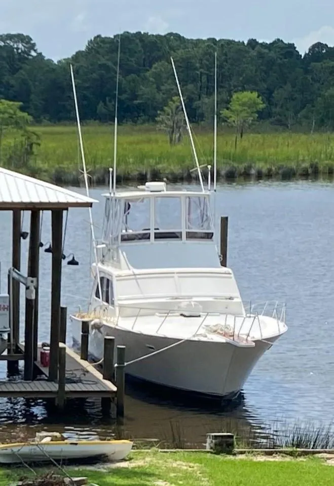 Slide: The Image of 1984 Post Sportfish boat docked by a riverside pier. - 4