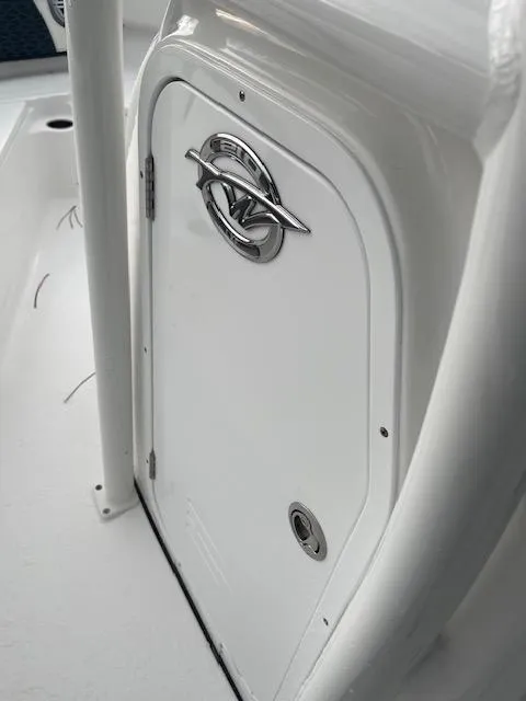 Slide: The Image of 2024 Tidewater 210 LXF boat compartment with sleek white finish and chrome handle. - 12