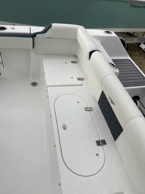 Slide: The Image of 2024 Tidewater 210 LXF boat interior, featuring white seating and storage compartments. - 15