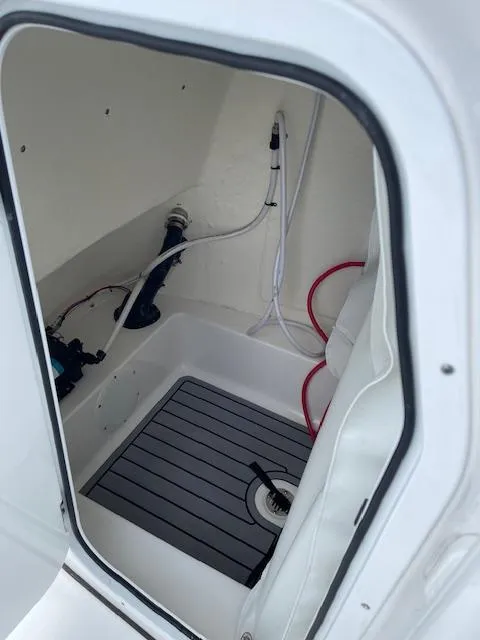 Slide: The Image of 2024 Tidewater 210 LXF boat interior compartment with plumbing and drainage system. - 20
