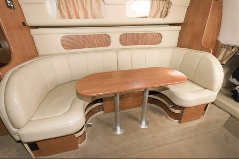 Slide: The Image of 2006 Rinker 342 Express Cruiser interior seating area with wooden table. - 11