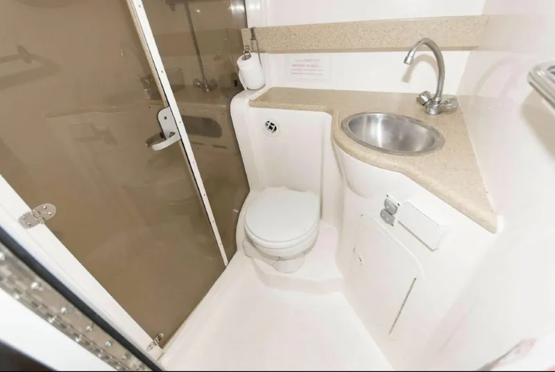 Slide: The Image of 2006 Rinker 342 Express Cruiser bathroom with toilet, sink, and shower. - 14
