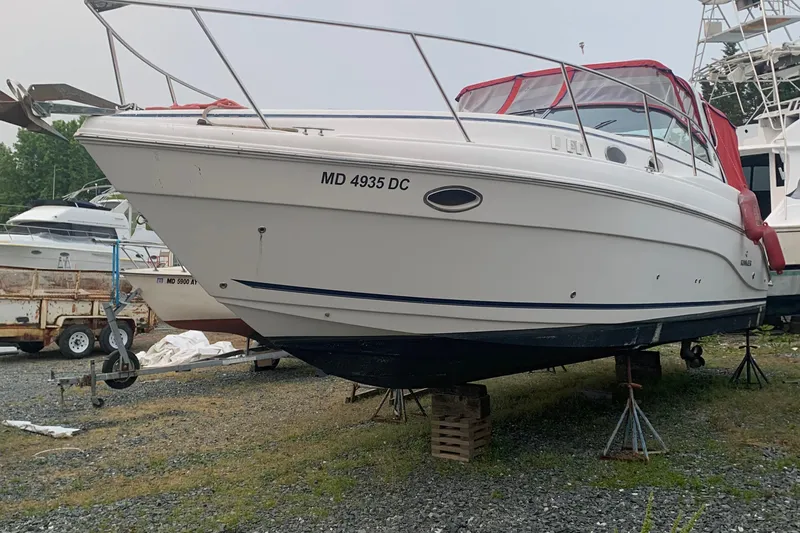 Slide: The Image of 2006 Rinker 342 Express Cruiser on stands, red canopy, boatyard background. - 3