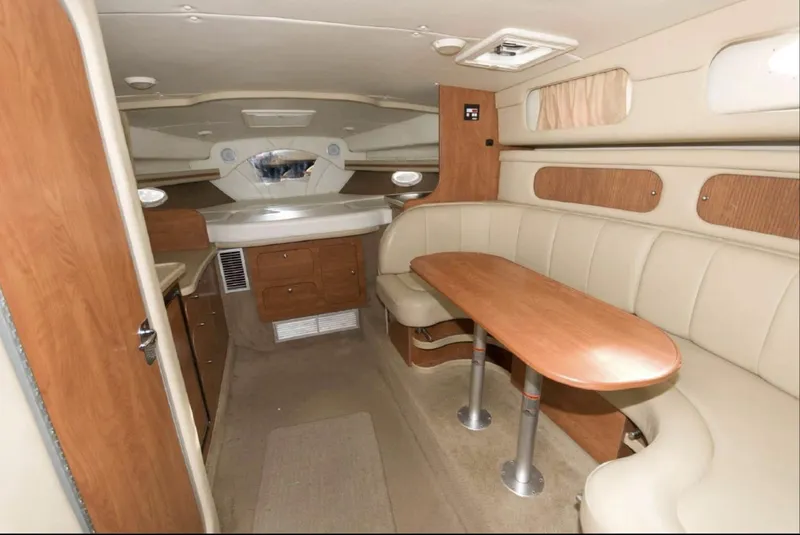 Slide: The Image of Interior of 2006 Rinker 342 Express Cruiser with beige seating and wooden table. - 9