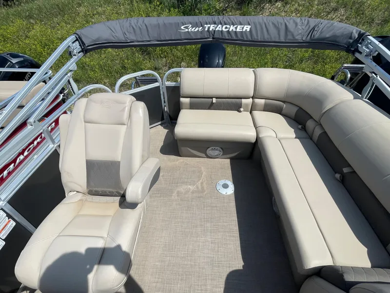 Slide: The Image of 2021 Sun Tracker Party Barge 20 DLX interior with beige seating and canopy. - 10
