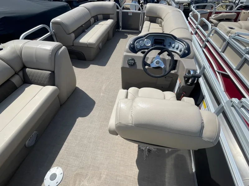 Slide: The Image of 2021 Sun Tracker Party Barge 20 DLX interior with beige seating and helm station. - 12