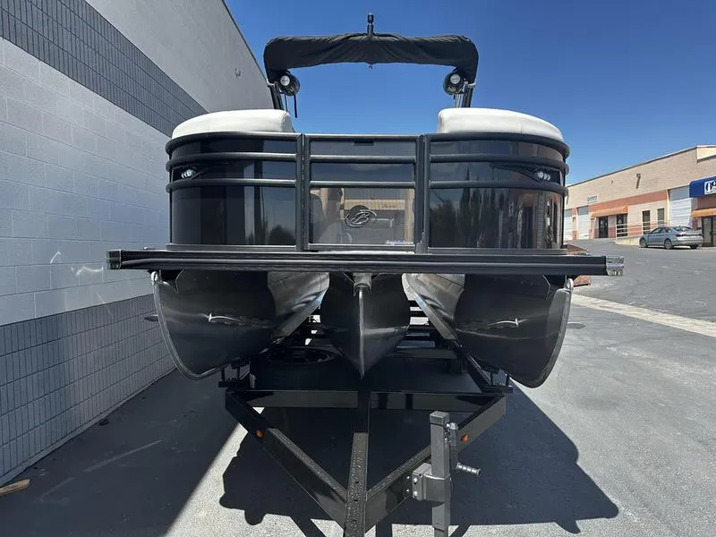 Slide: The Image of 2023 Barletta 23UA pontoon boat on a trailer, parked outdoors. - 10