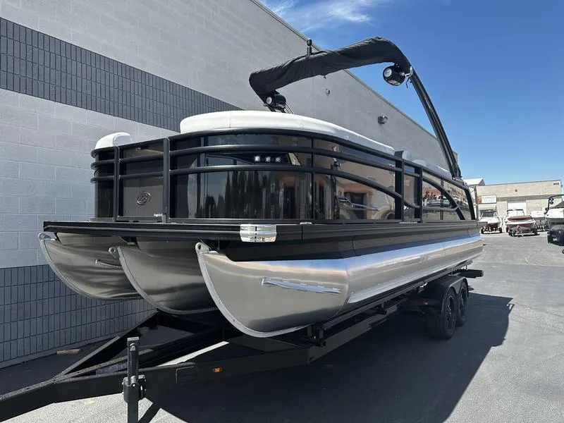 Slide: The Image of 2023 Barletta 23UA pontoon boat on trailer, parked outside a building. - 3