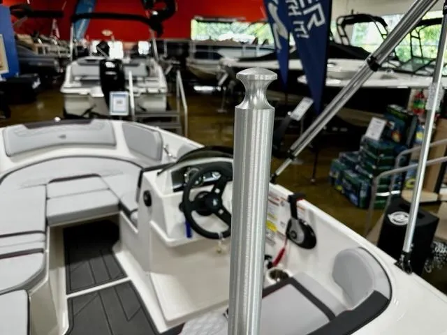 Slide: The Image of 2024 Bayliner Element M15 boat interior at a showroom, featuring steering wheel and seating. - 5