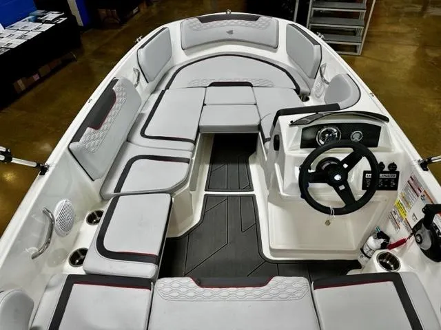 Slide: The Image of 2024 Bayliner Element M15 boat interior with cushioned seating and steering console. - 7