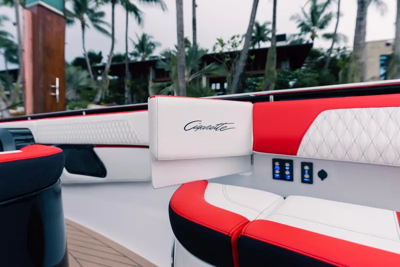 Slide: The Image of 2024 Cigarette 52 Thunder boat interior with red and white seating, palm trees in background. - 6