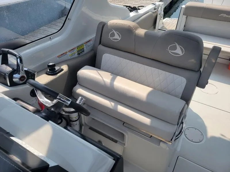 Slide: The Image of 2024 Finseeker 260 DC boat interior with steering wheel and cushioned seating. - 11