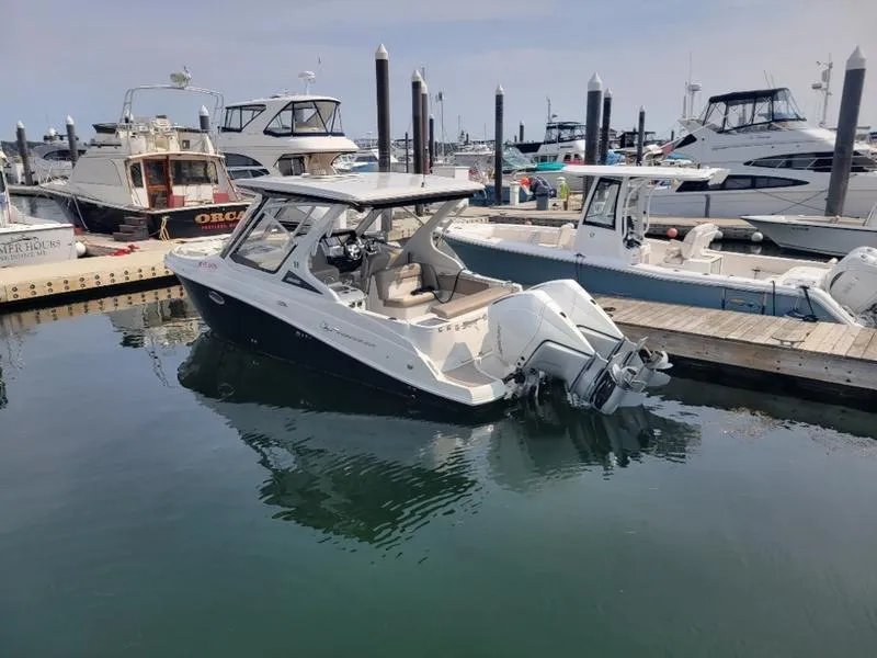 Slide: The Image of 2024 Finseeker 260 DC boat docked in a marina, surrounded by other vessels. - 19
