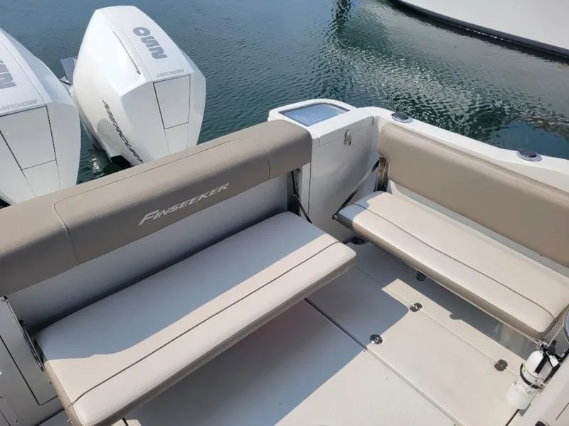 Slide: The Image of 2024 Finseeker 260 DC boat interior with seating and dual outboard engines. - 9