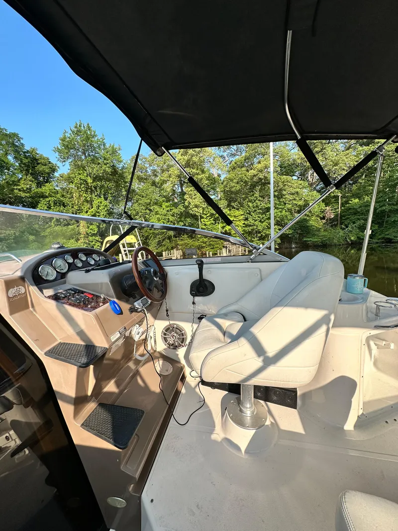 Slide: The Image of 2006 Regal Commodore boat interior with steering wheel, dashboard, and seating under canopy. - 5